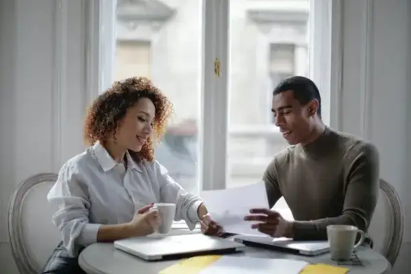Couple sitting at a desk with a laptop