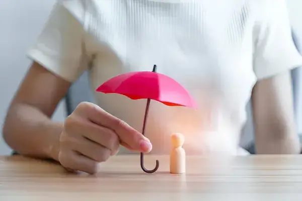 a child hold in tiny umbrella on a table
