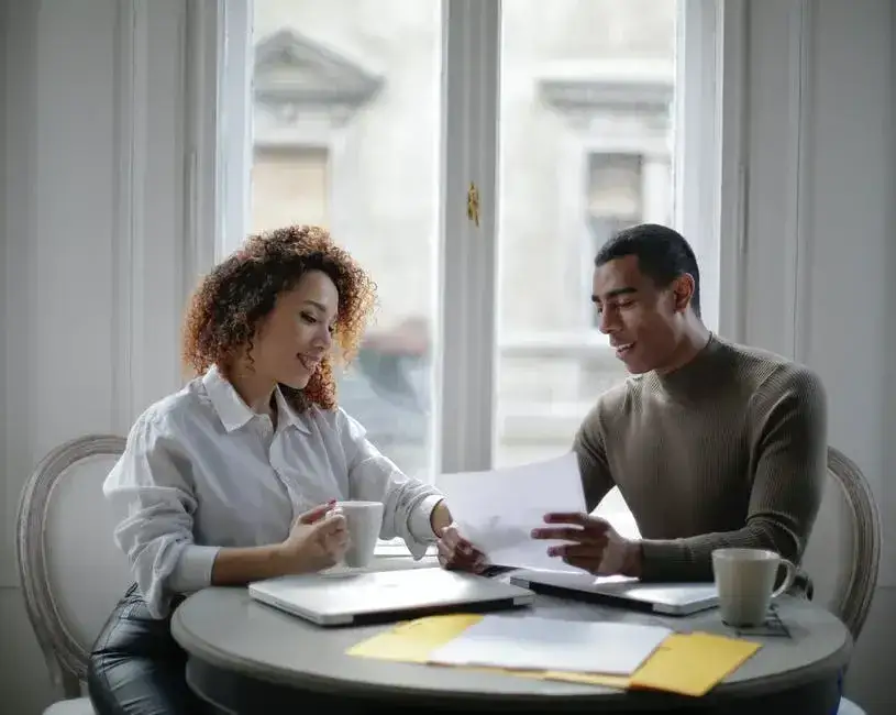 Couple sitting at a desk with a laptop