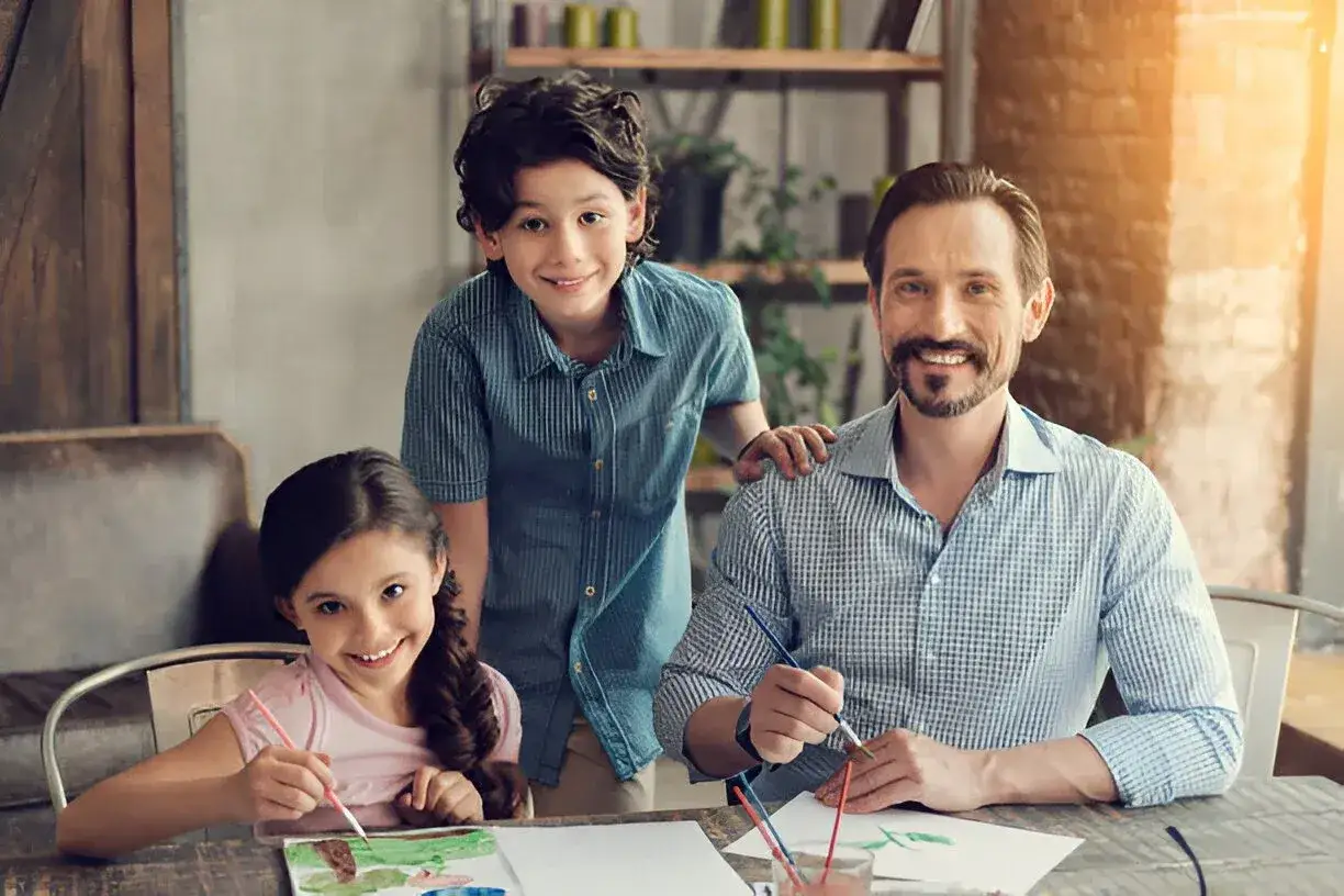Uncle sitting with kids at kitchen table 