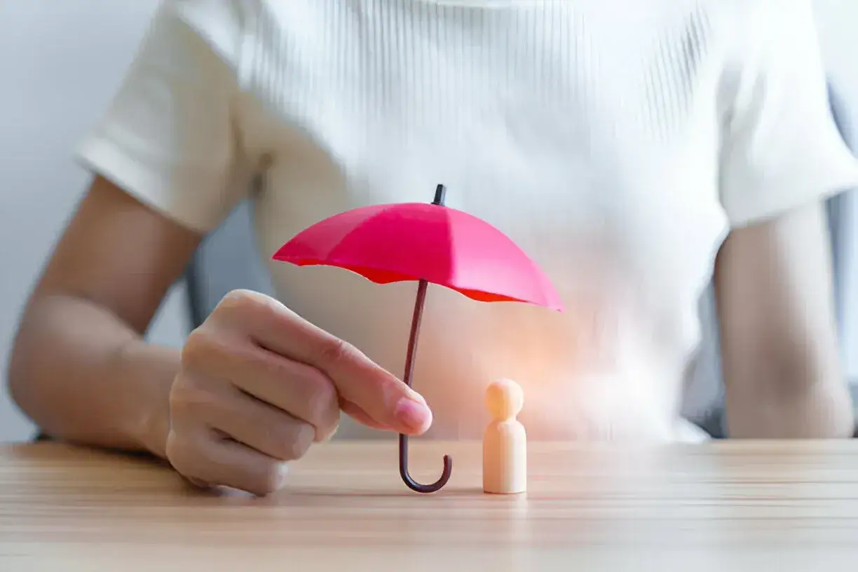 a child hold in tiny umbrella on a table